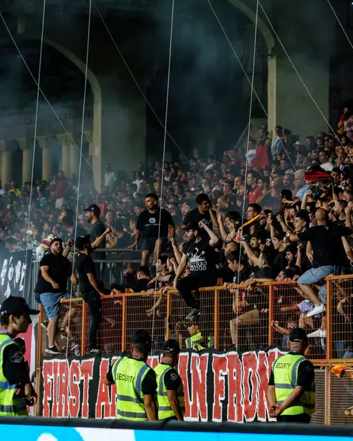 Home supporters in the stand with smoke and banners