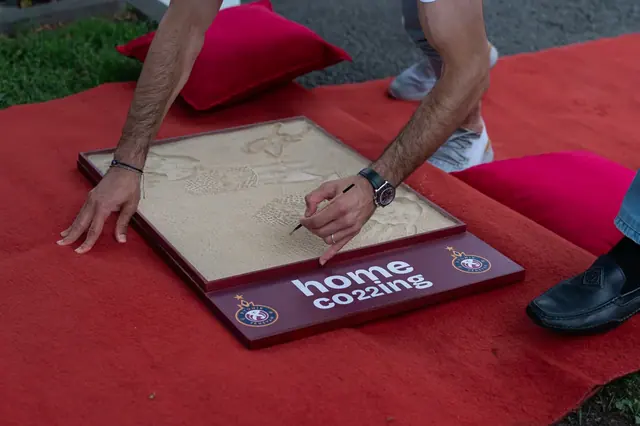 Hands signing a commemorative plaque at a corporate opening